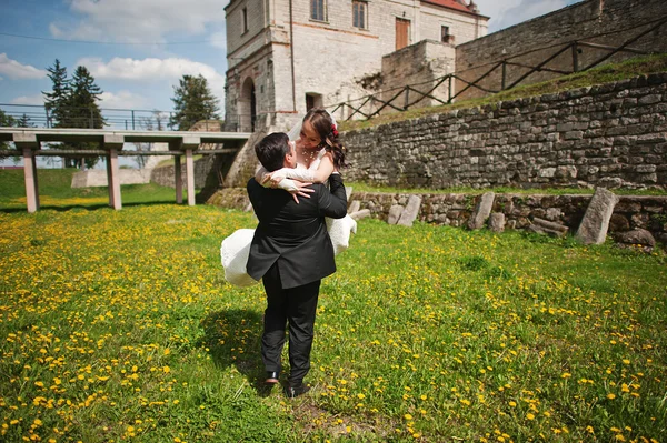 タンポポのフィールドで古いお城近くの結婚式のカップル — ストック写真