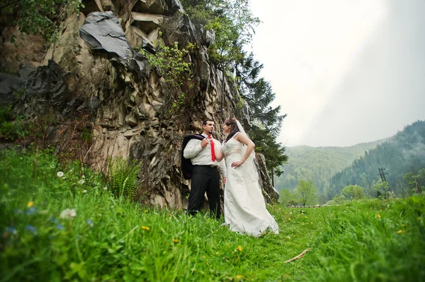 Pareja de boda cerca de rock — Foto de Stock