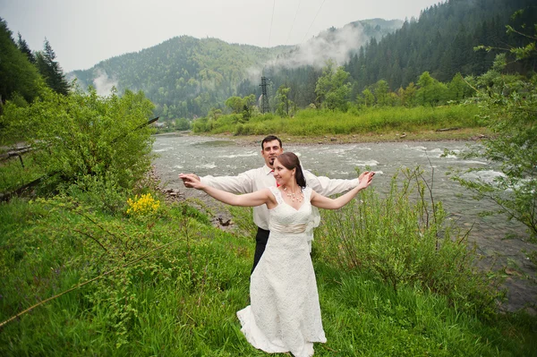 Свадебная пара возле реки с туманом — стоковое фото
