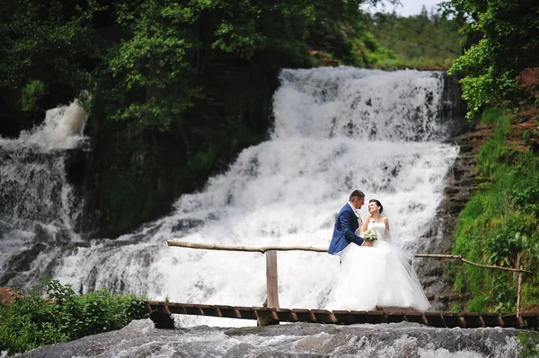 Hermosa pareja de boda cerca de cascada —  Fotos de Stock