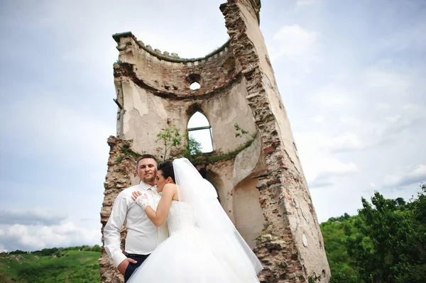 Schönes Hochzeitspaar in der Nähe von Ruinen Turm der alten Burg — Stockfoto