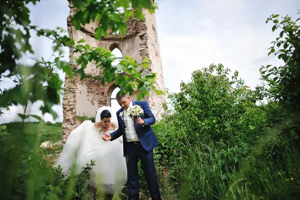 Beautiful wedding couple near ruins tower of old castle — Stock Photo, Image