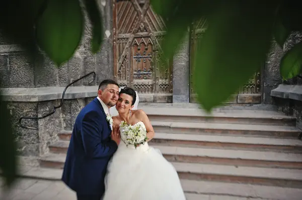 Abraço recém-casado perto de escadas igreja velha — Fotografia de Stock