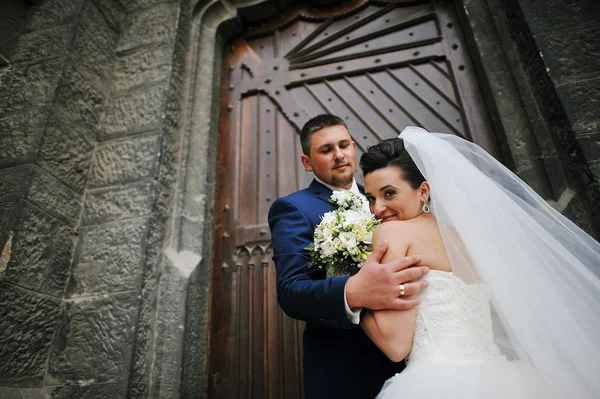 Wedding couple near old catholic church — Stock Photo, Image