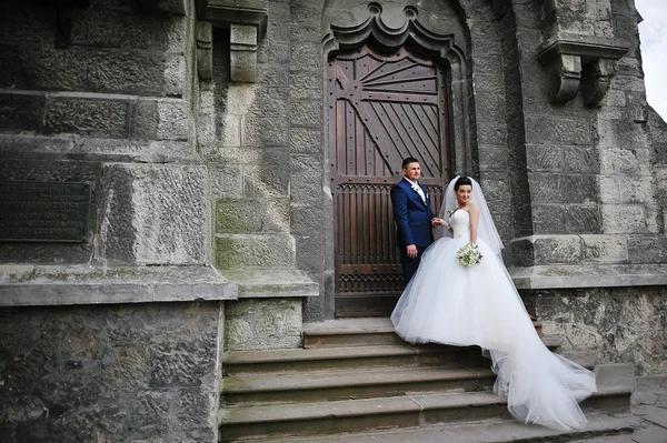 Wedding couple near old catholic church — Stock Photo, Image