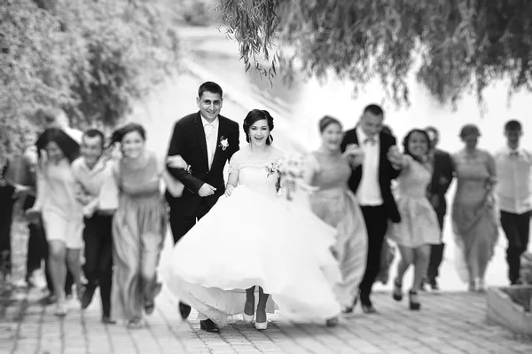 Happy newlywed running with they friends — Stock Photo, Image