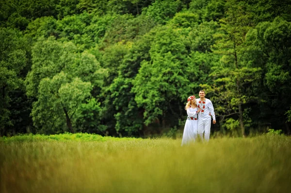 Jonge mooie paar in traditionele kleding wandelen — Stockfoto