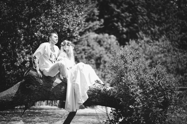 Young  beautiful couple in traditional dress at the tree up the — Stock Photo, Image