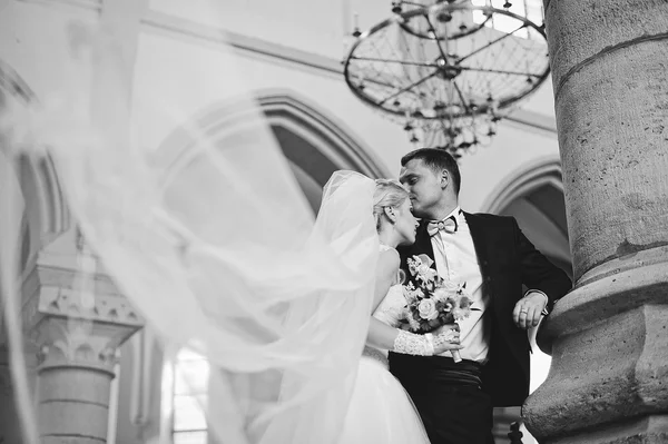 Young beautiful wedding couple at the old catholic church — Stock Photo, Image