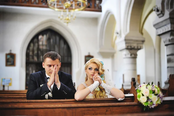 Joven hermosa pareja de boda en la antigua iglesia católica — Foto de Stock