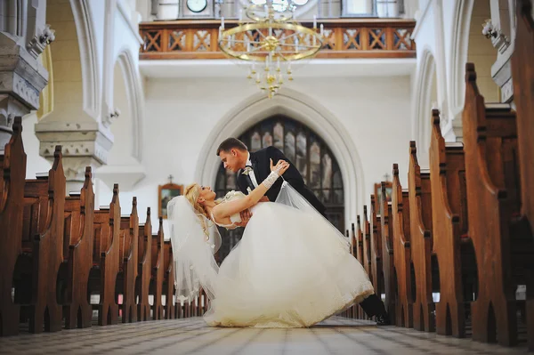 Young beautiful wedding couple at the old catholic church — Stock Photo, Image