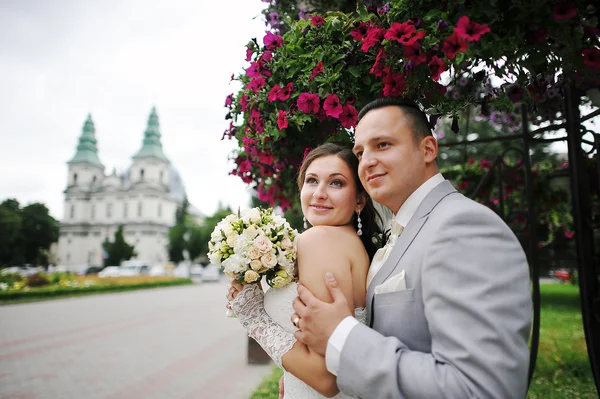 Happy married hugging on background church — Stock Photo, Image