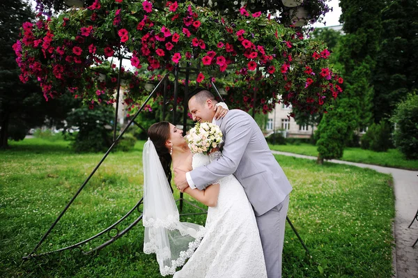 Joyeux couple de mariage sur backqround fleurs rouges — Photo