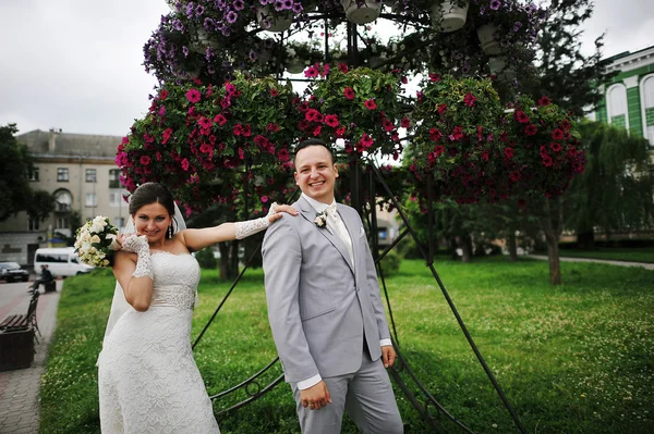 Casal feliz no backqround flores vermelhas — Fotografia de Stock