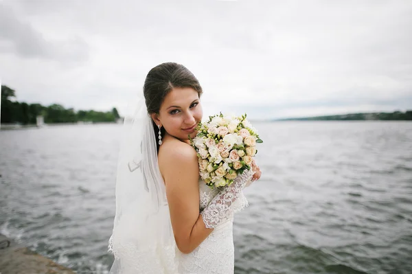 Bride on the windy weather near the lake — Stock Photo, Image