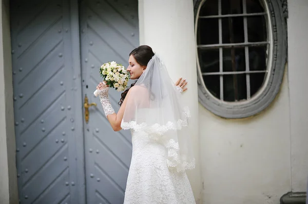 Novia con ramo cerca de columnas — Foto de Stock