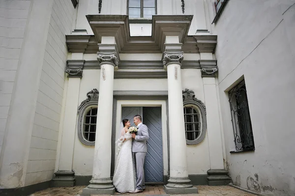 Свадебная пара рядом со старыми каменными колоннами — стоковое фото