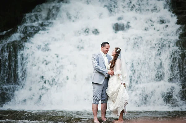 Glückliches Brautpaar in der Nähe des Wasserfalls — Stockfoto