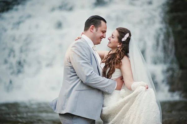 Felices recién casados cerca de la cascada —  Fotos de Stock