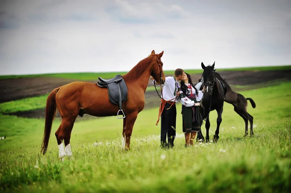 घोड़ों के साथ राष्ट्रीय पोशाक पर युवा जोड़े — स्टॉक फ़ोटो, इमेज