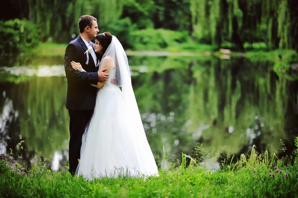 Casamento casal nas pedras perto do lago — Fotografia de Stock