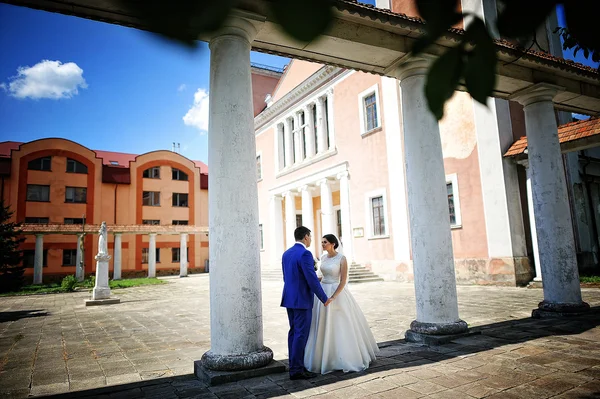 Coppia appena sposata vicino vecchie colonne — Foto Stock