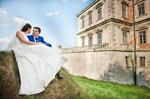 Unga brudparet på bakgrunden gamla slottet — Stockfoto