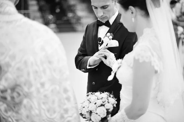 Bruden sätter en vigsel ring på brudgummens finger — Stockfoto