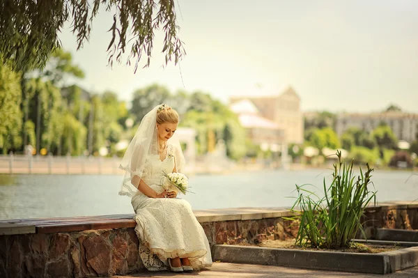 Szőke menyasszony ült, tó közelében — Stock Fotó