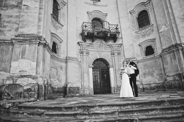 Coppia appena sposata che cammina innamorata alla vecchia chiesa — Foto Stock