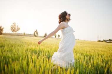 Buğday ve pop ile sahada hamile güzel esmer kadın