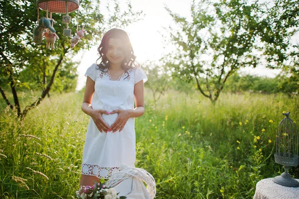 Zwangere prachtige brunette vrouw op het veld met tarwe en pop — Stockfoto