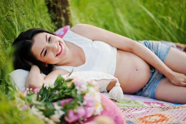 Schwangere wunderschöne brünette Frau auf dem Feld mit Weizen und Knall — Stockfoto
