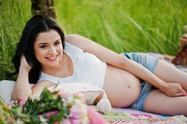 Schwangere wunderschöne brünette Frau auf dem Feld mit Weizen und Knall — Stockfoto