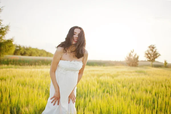 Pregnant gorgeous brunette woman on the field with wheat and pop — Stock Photo, Image