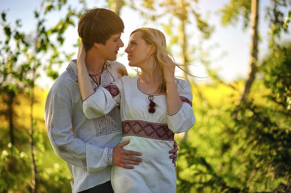 Casal no vestido tradicional no campo de flores amarelas — Fotografia de Stock