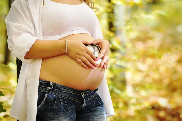 Femme enceinte tenant la main sur sa bosse de bébé — Photo