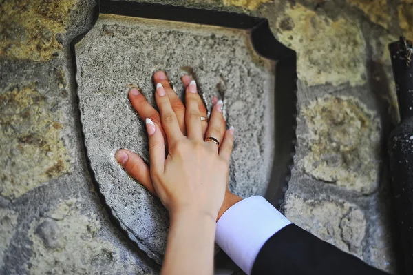 Hands of wedding couple on stone — Stock Photo, Image