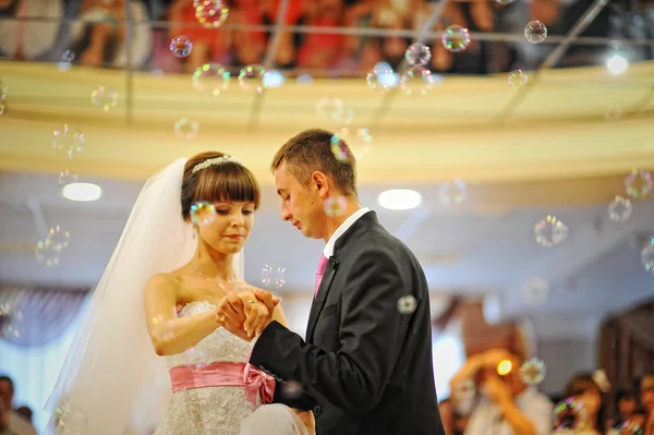 Bruid en bruidegom dansen in het restaurant op bubbels — Stockfoto