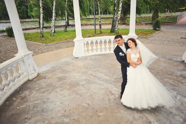 Matrimonio coppia sotto arco bianco — Foto Stock