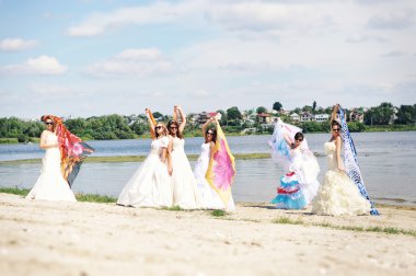 brides having fun on the beach