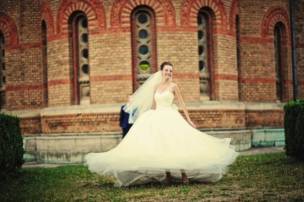 Bride dance with her dress near vintage building — Stockfoto