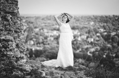 Bride posed over cliff