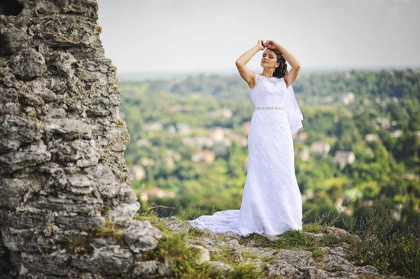 Bride posed over cliff — Stock fotografie