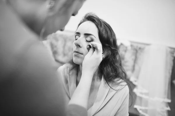 Young brunette bride applying wedding make-up by make-up artist — Stock Photo, Image