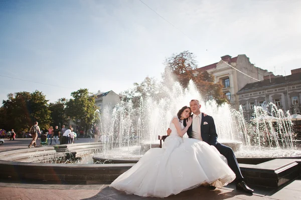 Walking par sitter nära fountain — Stockfoto