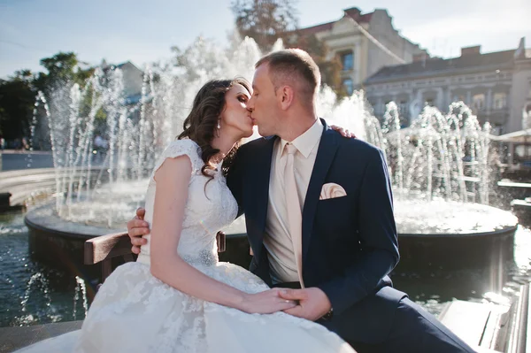 Walking couple sitting near fountain — Stock Photo, Image