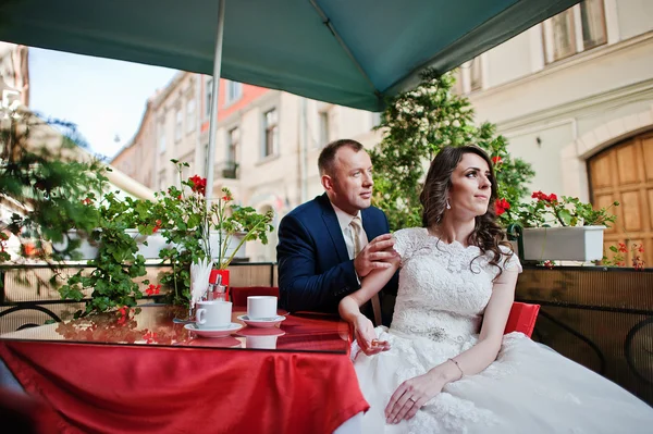 Házasok kávéház piros asztalánál ül — Stock Fotó
