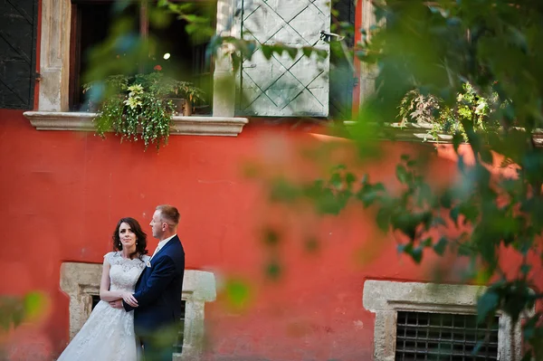 Pareja de boda fondo naranja pared de la casa con victoria original — Foto de Stock