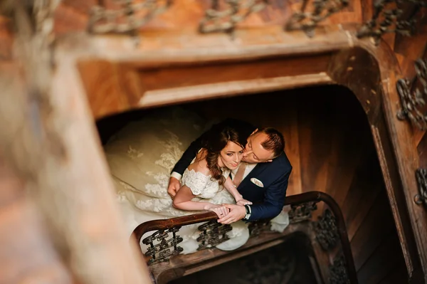 Frisch verheiratet im hölzernen Treppenhaus eines antiken Gebäudes — Stockfoto